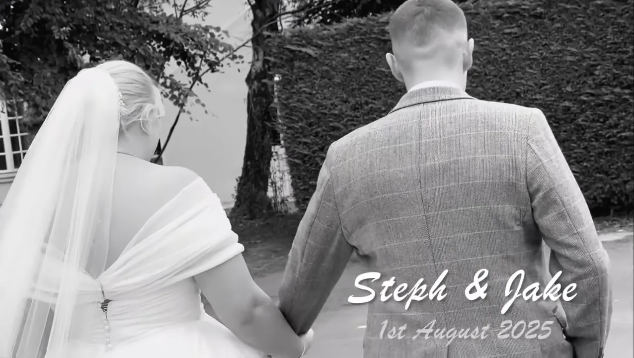Black and white shot of the couple walking away hand in hand